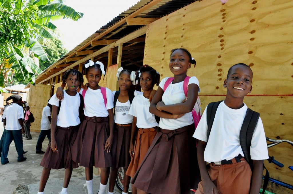 Children smile outside classroom