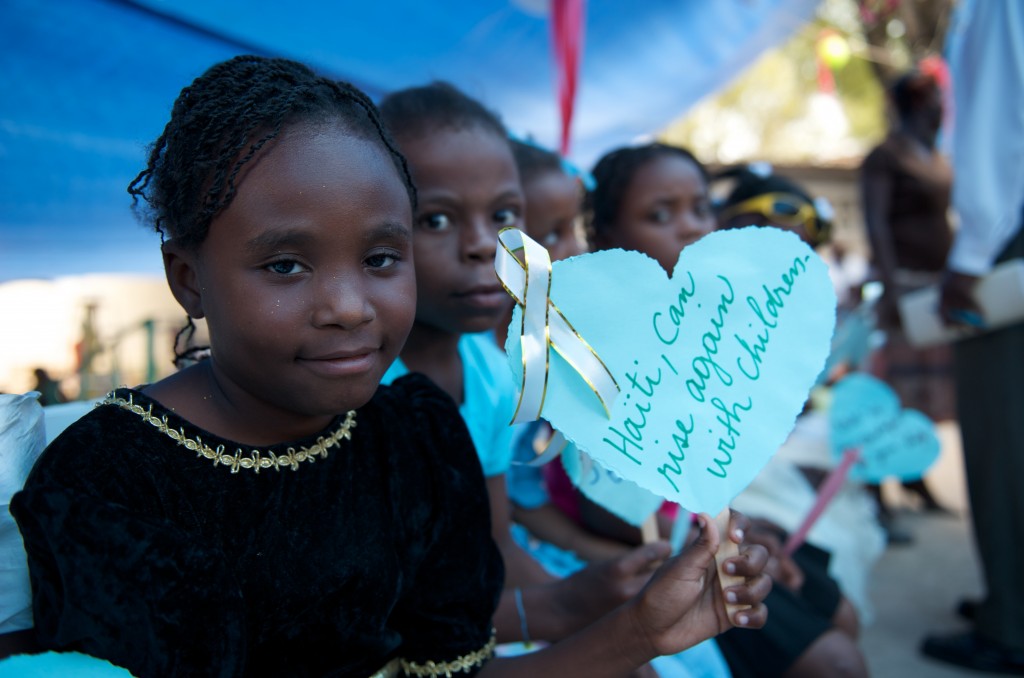 Children holding heart shaped cards of thanks