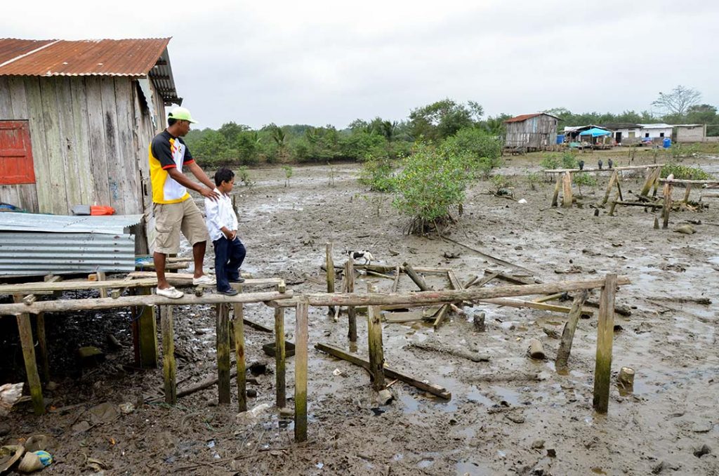 Dastin and his dad looking at the site where their home once stood. Instead of a home there is just a muddy bog.