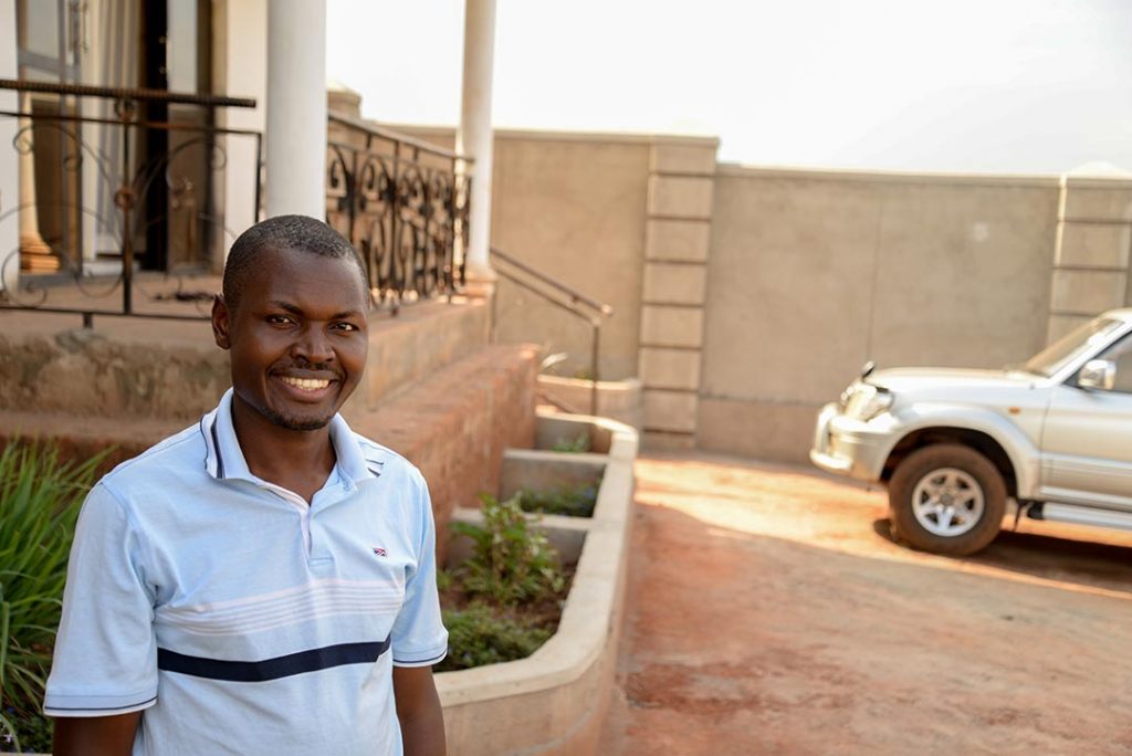 A Ugandan man stands outside of his law office.