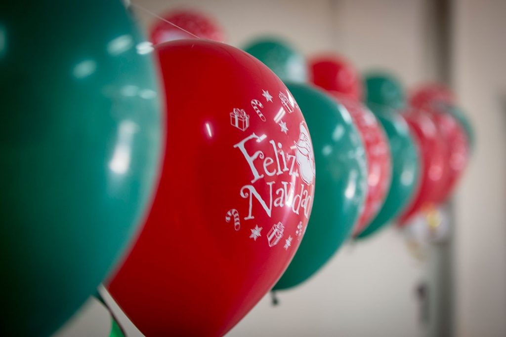 Red and green Christmas balloons hanging on a string.