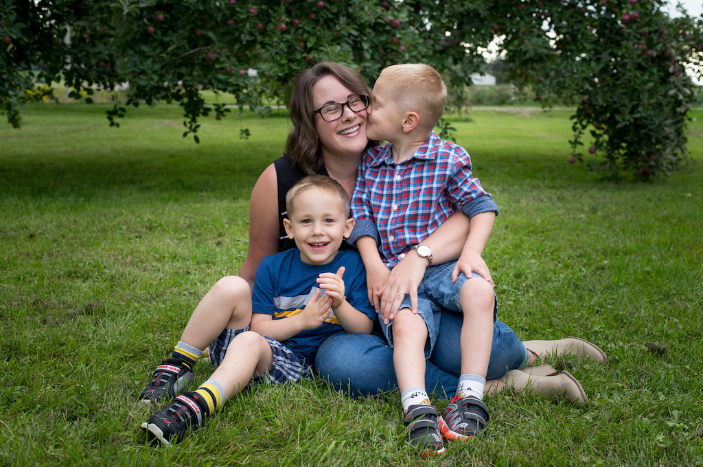 Christine and her twin boys sitting on the grass.