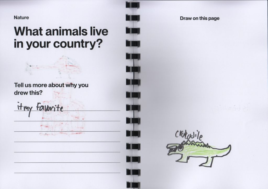 A picture of an open notebook with a drawn picture of an alligator.